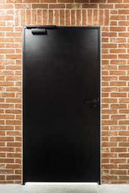 Bir duvarında modern siyah kapı
