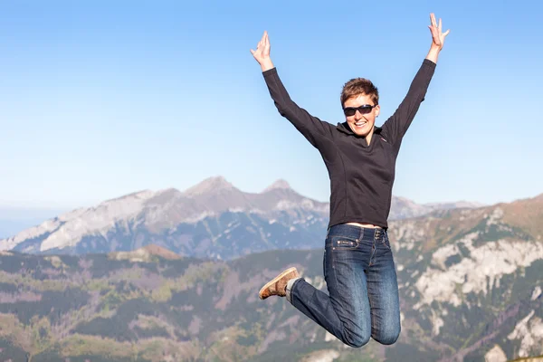 Feliz turista de salto en las montañas — Foto de Stock