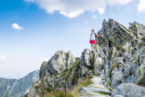 Молодая женщина, карабкающаяся на высокие горы — стоковое фото