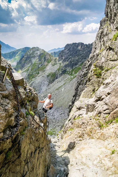 Middelste leeftijd man wandelen en klimmen bergen. — Stockfoto