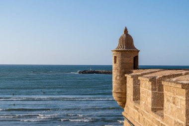 Rabat, Udayas 'ın tarihi Kasbah' ının Atlantik Okyanusu 'na bakan Fas Manzarası. Fas bayrağı deniz kenarındaki antik kale duvarları üzerinde dalgalanır taş yolları ve berrak gökyüzünün altında mavi su vardır.. 