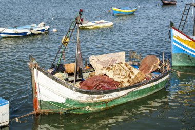 Rabat, Fas Bou Regreg Nehri manzaralı renkli balıkçı tekneleri nazikçe suda yüzüyor ve arka planda tarihi Hasan Kulesi yükseliyor. Açık ve güneşli bir günde yakalanan bu resim geleneğin karışımını sergiliyor. 