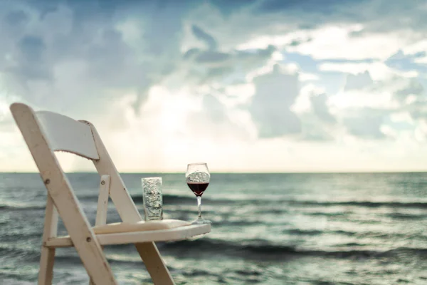 Cadeira branca com vinho em uma praia — Fotografia de Stock