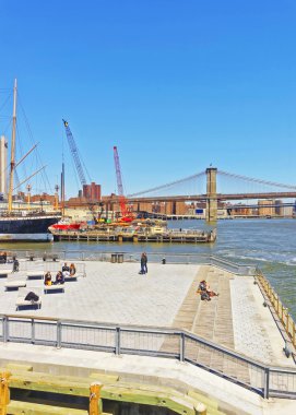 Manhattan'daki Pier'de şezlonglarda dinlenen turistler
