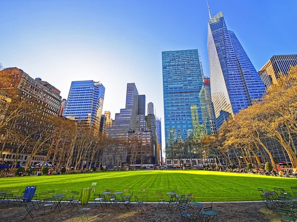 Mesas e cadeiras e arranha-céus vistos de Bryant Park — Fotografia de Stock