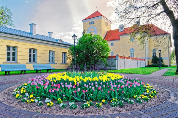 Letonya çiçek tarhında Ventspils Kale ve laleler — Stok fotoğraf