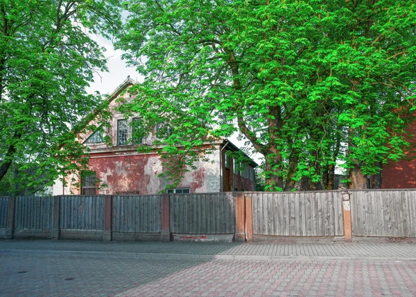 Antigua casa con una cerca de madera en Ventspils de Letonia — Foto de Stock