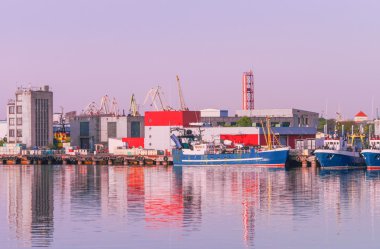 Gemiler ve gün batımında, Ventspils Marina'da Vinçler