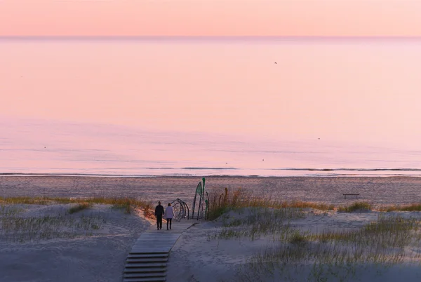 Couple à la plage au coucher du soleil dans la mer Baltique — Photo