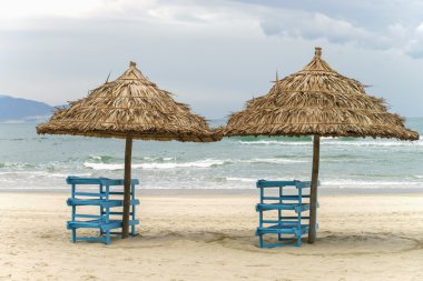 China Beach'te palmiye barınakları ve şezlonglar