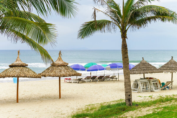 Palms and sunbeds in China Beach in Da Nang