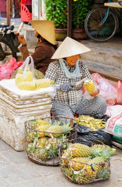 Hoi An sokaklarında ananas satan Asyalı kadın