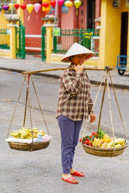 Rambutan mango ve muz taşıyan Asyalı kadın satıcı