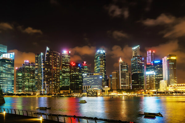 Singapore, Singapore - February 29, 2016: Singapore skyline of Downtown Core at Marina Bay at night. Cityscape of famous Skyscrapers illuminated with light and reflected in the water.