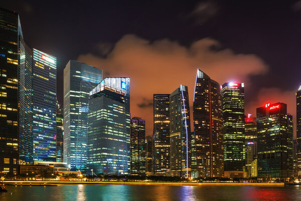 Singapore, Singapore - February 29, 2016: Singapore skyline on Downtown Core at Marina Bay at night. Cityscape of famous Skyscrapers illuminated with light and reflected in the water.