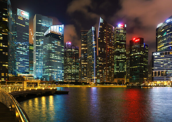 Singapore, Singapore - February 29, 2016: Singapore skyline of Downtown Core at Marina Bay at dusk. Cityscape of famous Skyscrapers illuminated with light and reflected in the water.