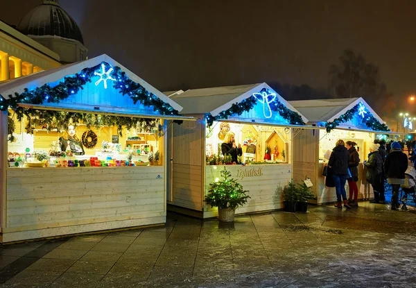 Mensen die op zoek zijn naar feestelijke producten op de kerstmarkt van Vilnius — Stockfoto