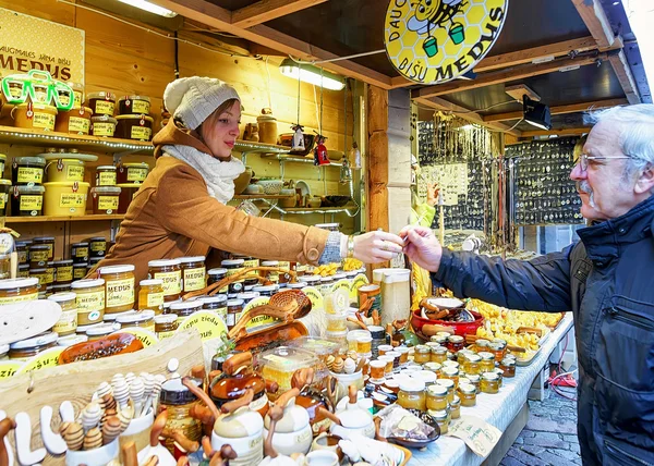 Mladá žena prodávající keramiku a med na vánočním trhu v Rize — Stock fotografie