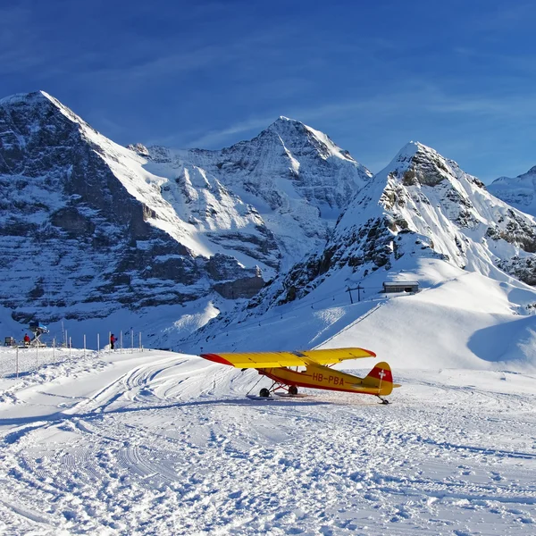 Gele vliegtuig op de Zwitserse winter mountain skiresort — Stockfoto