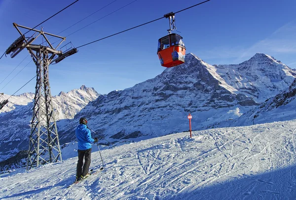 Los hombres en esquí cerca del ferrocarril por cable en la estación de deportes de invierno en Suiza al — Foto de Stock