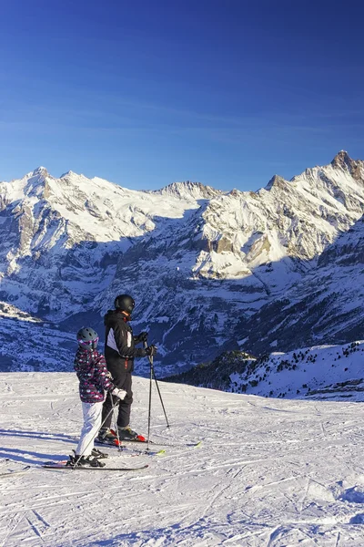Männer und Kinder auf Skiern im Wintersportort in den Schweizer Alpen — Stockfoto