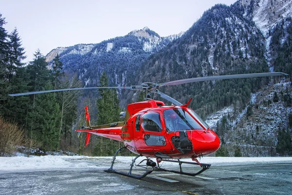 Hélicoptère rouge à la base dans les Alpes suisses — Photo