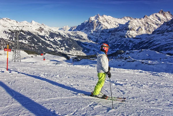Menina no esqui na encosta da montanha na região de jungfrau alpes suíços — Fotografia de Stock