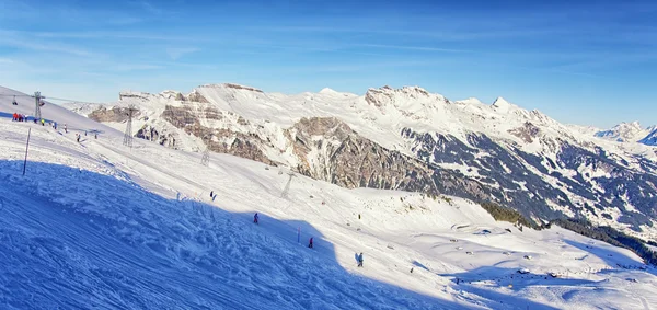 Personas en esquí y snowboard en estación de deportes de invierno en Suiza al —  Fotos de Stock