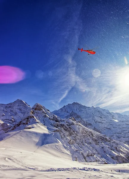 Hélicoptère rouge dans le ciel aux Alpes suisses près de la montagne Jungfrau — Photo