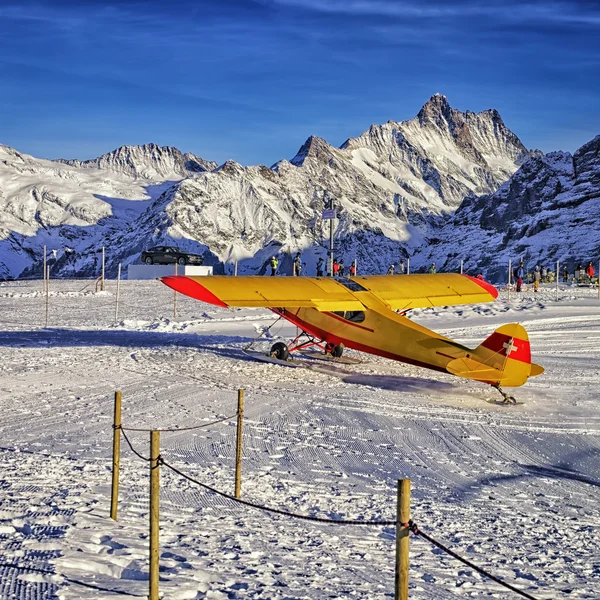 Mountain ski resort Havaalanı İsviçre, sarı kırmızı uçak — Stok fotoğraf