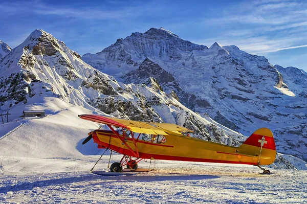 Avion jaune rouge à l'aérodrome de montagne dans les Alpes suisses — Photo