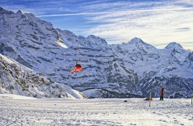 Kırmızı helikopter swiss ski resort yakınındaki Jungfrau mounta üzerinde uçan