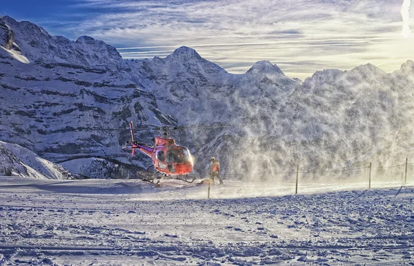 Červený vrtulník přistál u švýcarského lyžařského střediska poblíž Jungfrau mountain — Stock fotografie