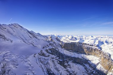 Coomb, wall and peak in Jungfrau region helicopter view in winte clipart