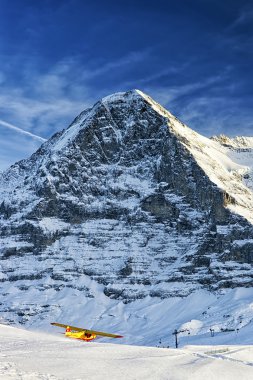 Sarı uçak w İsviçre Alpleri'nde alpine Resort kalktıktan