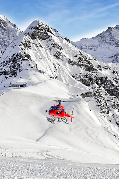 Hélicoptère rouge atterrissant à la station de ski suisse près du pic Tschuggen — Photo