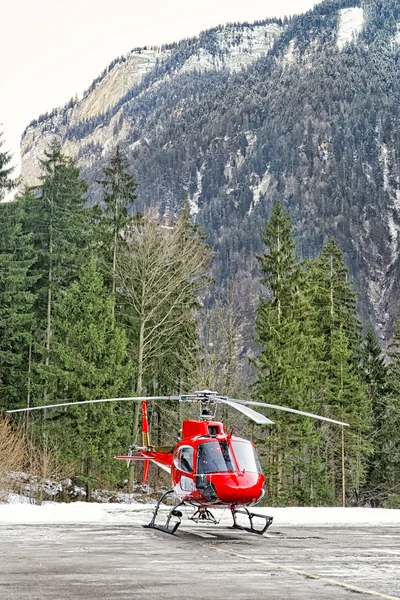 Helicóptero vermelho pousou no heliporto alpino suíço — Fotografia de Stock