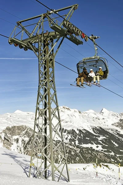 Familie op ski in de kabelbaan — Stockfoto