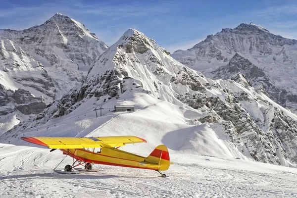 Gelb-rotes Flugzeug auf dem Bergflugplatz in den Schweizer Alpen — Stockfoto