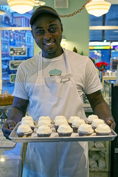 Χαμογελώντας μαύρος με cupcakes στο δίσκο — Φωτογραφία Αρχείου