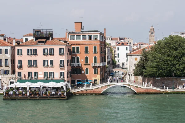 Quay, restaurant and bridge over channel in Venice — Stock Photo, Image