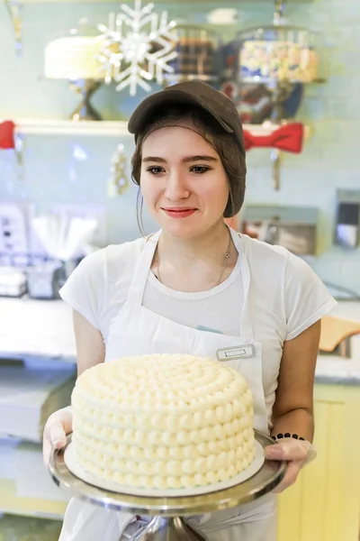 Χαμογελαστό κορίτσι με κρεμώδη τούρτα στο αρτοποιείο — Φωτογραφία Αρχείου