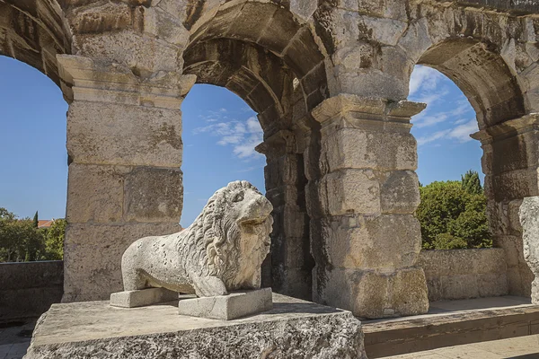 Väggen fragment av antika romerska amfiteatern med en lion monument — Stockfoto