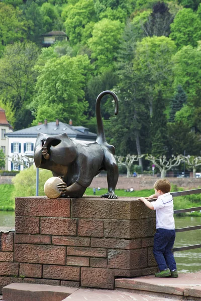 Boy playing near monkey statue on the bridge in summer Heidelber — Stock Photo, Image
