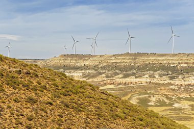 Rüzgar türbinleri önünde mavi gökyüzü tepe üzerinde