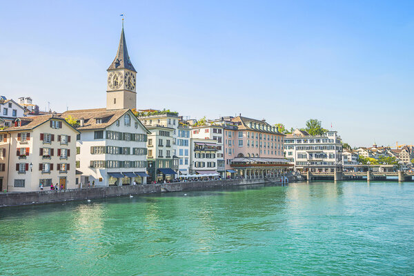 Zurich city center and Limmat quay in summer with Cathedral and city hall clock towers spires in summertime