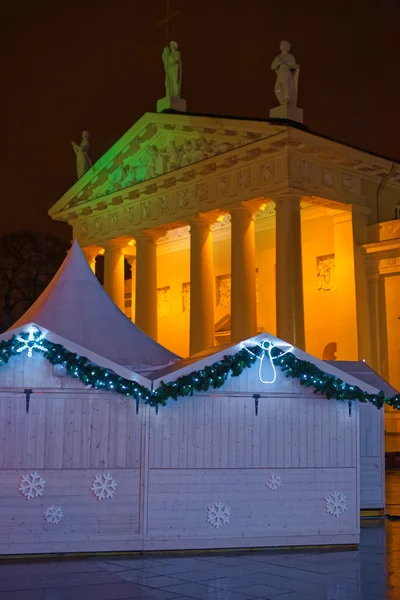 Iluminado Vilnius Catedral y quiosco de mercado de Navidad en holi —  Fotos de Stock