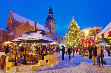 İnsanlar Noel pazarı Riga'da tadını çıkarın.