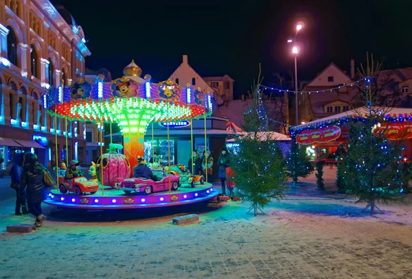 Little kids riding a merry-go-round at the traditional Christmas — Stock Photo, Image