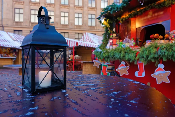 Фонарь с горящей свечой на столе на рождественской ярмарке в — стоковое фото